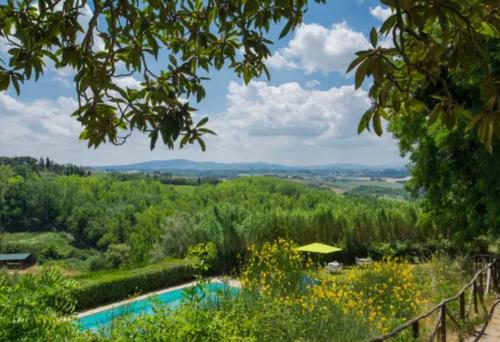 a swimming pool in a garden with a fence and trees at Agriturismo La Moraia in Poggibonsi