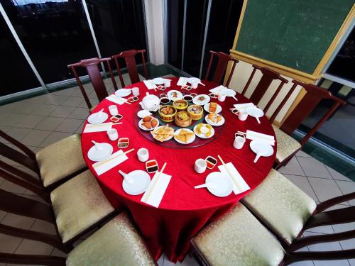 a red table with plates of food on it at Hotel Sandakan in Sandakan