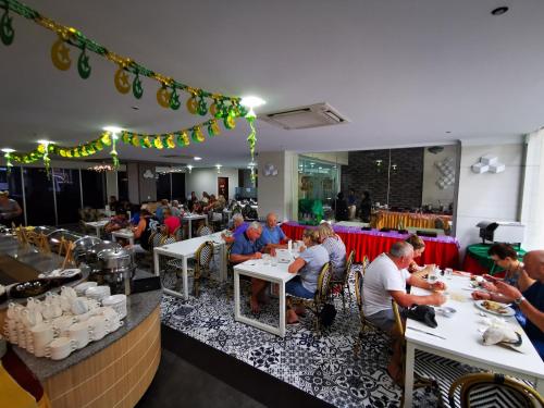 a group of people sitting at tables in a restaurant at Hotel Sandakan in Sandakan