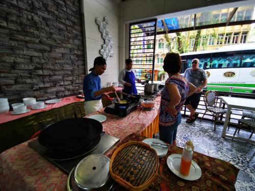 a group of people standing at a counter in a restaurant at Hotel Sandakan in Sandakan