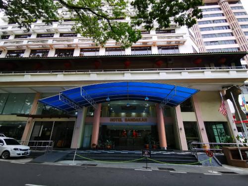 um edifício com um dossel azul em frente em Hotel Sandakan em Sandakan