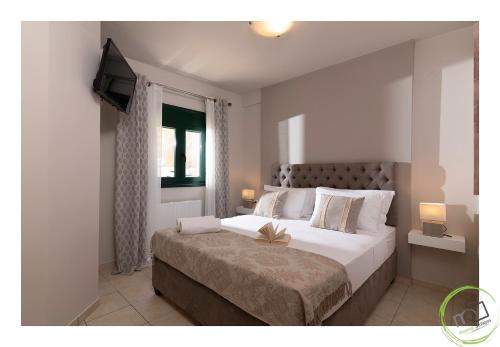 een slaapkamer met een groot bed en een televisie bij Irini apartment in Piskopiano, Hersonissos #1 in Chersonissos