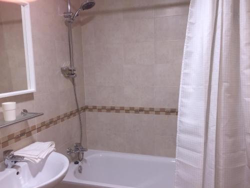 La salle de bains est pourvue d'une baignoire, d'un lavabo et d'une douche. dans l'établissement PLAZA, à Segura