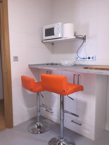 an orange bar stool in a kitchen with a microwave at PLAZA in Segura