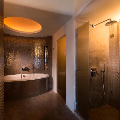 a bathroom with a bath tub and a shower at Avaton Resort And Spa in Imerovigli