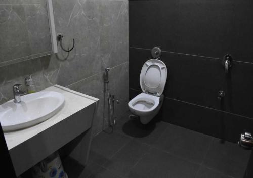 a bathroom with a white toilet and a sink at Hotel President Banquet & Lawn in Aurangabad