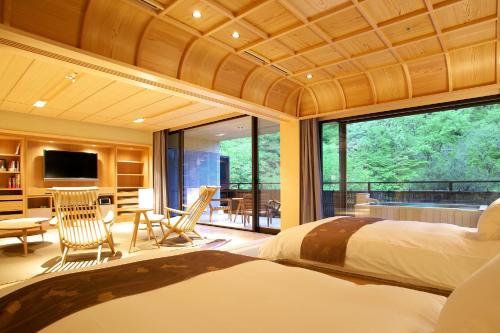 a bedroom with a large bed and a large window at Kaichoro in Shibukawa