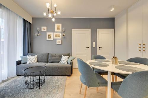 sala de estar con sofá, mesa y sillas en Comfort Apartments Rajska, en Gdansk