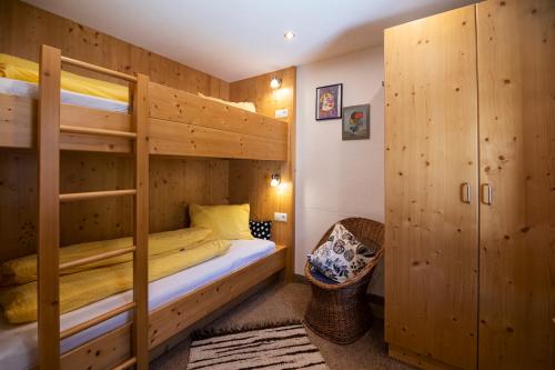 a bedroom with two bunk beds and a chair at Landhaus Gasser in Wenns