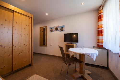 a room with a table and two chairs and a television at Landhaus Gasser in Wenns