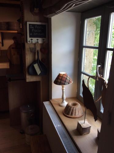 a lamp on a counter in a room with a window at Petite maison d'Amelotte in Sainte-Cécile
