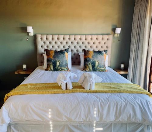 two stuffed animals sitting on top of a bed at Marianne Wine Estate in Stellenbosch