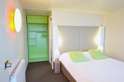 - une chambre avec un lit blanc et une porte verte dans l'établissement Campanile Reims Est - Taissy, à Reims