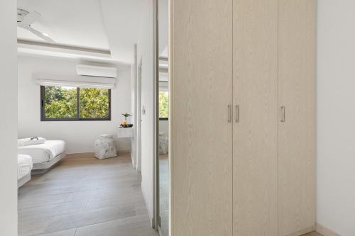 1 dormitorio con paredes blancas, suelo blanco y puerta corredera en Villa Heaven Tongson Bay Beach, en Thong Son Beach