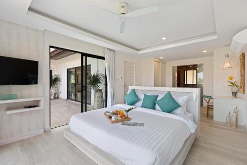 Un dormitorio con una cama blanca con almohadas azules. en Villa Heaven Tongson Bay Beach, en Thong Son Beach