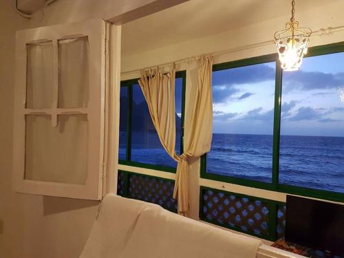 1 dormitorio con ventana y vistas al océano en Ocean front La Maresia Holiday 2 Apartments en Taganana
