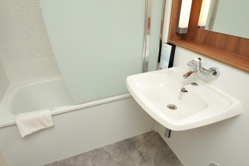 a bathroom with a sink and a mirror at Campanile Reims Est - Taissy in Reims