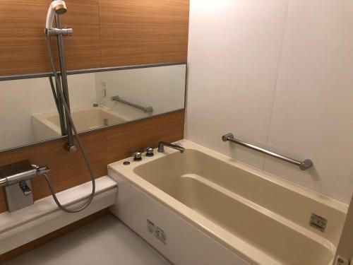 a bathroom with a bath tub and a sink at Restay Puchi Nagasaki Club (Adult Only) in Nagasaki