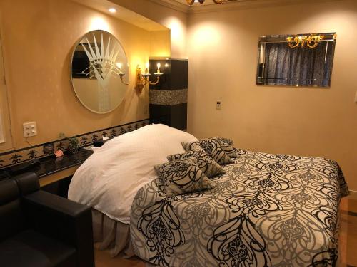 a bedroom with a bed and a mirror at Restay Puchi Nagasaki Club (Adult Only) in Nagasaki