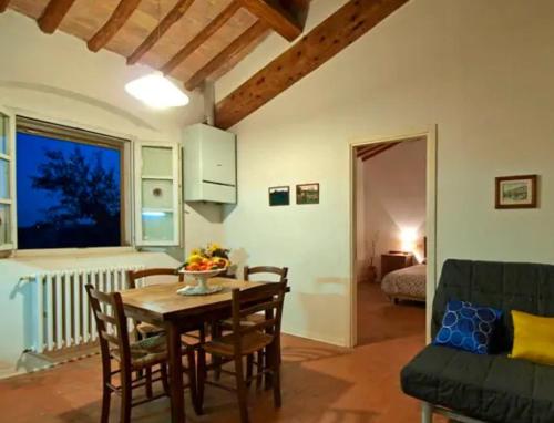 a living room with a table and chairs and a couch at Agriturismo La Moraia in Poggibonsi