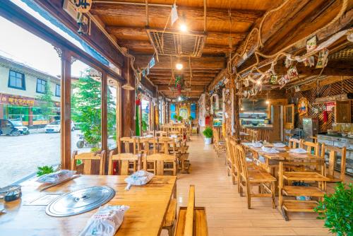 a restaurant with wooden tables and wooden chairs at Home Away From Home in Shangri-La
