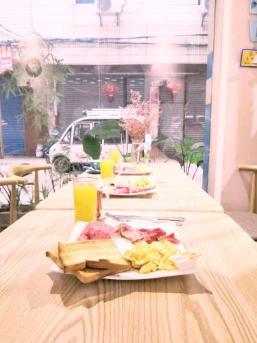 a table with two plates of food and drinks at Murphy Youth Hostel Guilin桂林北站莫非青年旅舍 in Guilin