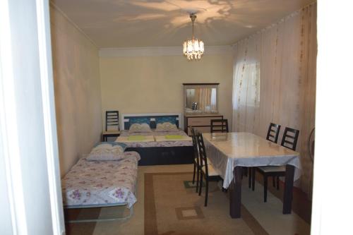 1 dormitorio con 2 camas, mesa y sillas en Shaki Host House, en Sheki