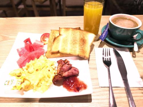 a breakfast plate with eggs bacon and toast and a cup of coffee at Murphy Youth Hostel Guilin桂林北站莫非青年旅舍 in Guilin