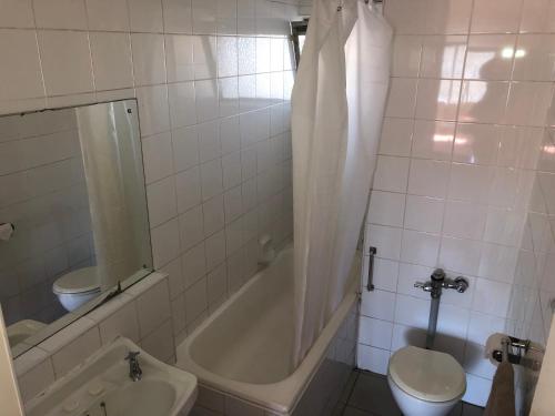 a bathroom with a tub and a toilet and a sink at Coastlands Durban Self Catering Holiday Apartments in Durban
