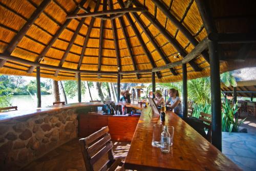 a bar in a restaurant with a wooden table at Omarunga Epupa-Falls Camp in Opuwo