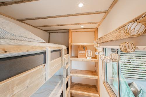 a bedroom with a bunk bed and a window at LODGES 7Huizen aan Zee in Scharendijke