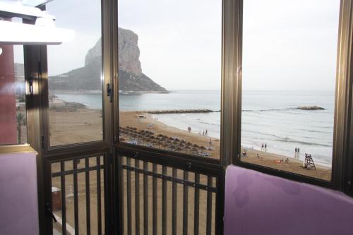 a view of a beach from a room with windows at Primera Linea de Playa con Garaje in Calpe