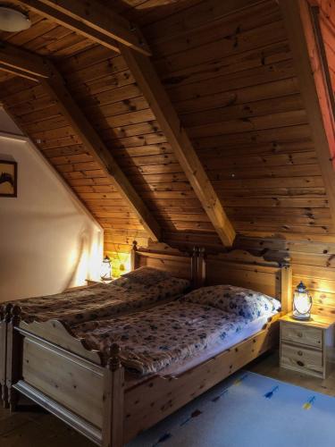 a bed in a room with a wooden ceiling at Tulipános vendégház in Fertőszentmiklós