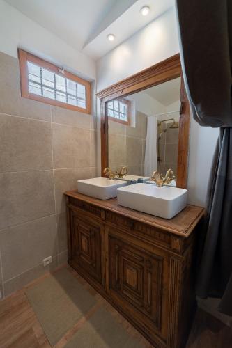 a bathroom with two sinks and a large mirror at Le Mas des Cerisiers JACUZZI et SAUNA inclus pour tous les logements in Avignon