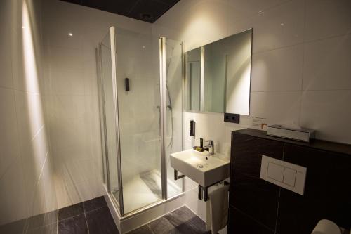 W łazience znajduje się prysznic i umywalka. w obiekcie Design Hotel Glow w Eindhoven