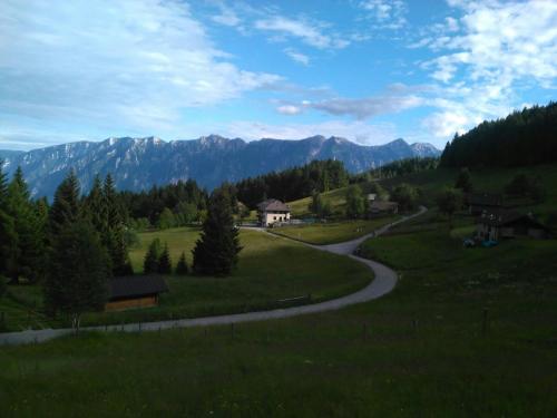 a winding road in a field with mountains in the background at Locanda La Ruscoletta in Telve