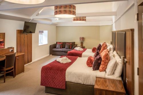 a bedroom with a large bed and a couch at Hellaby Hall Hotel; BW Signature Collection in Hellaby