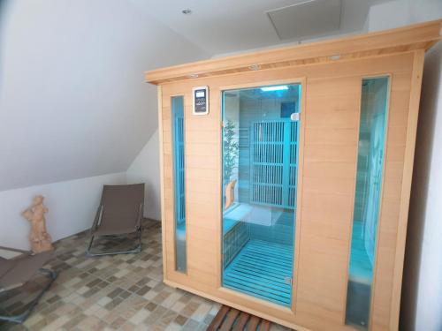 um recinto de madeira com uma porta de vidro num quarto em Au 36, Les Apparts Hotel Joigny em Joigny