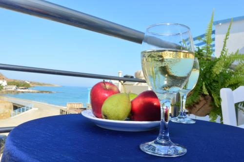 米拉托斯的住宿－Meltemi Beach Apartments，桌上放一盘苹果和一杯葡萄酒