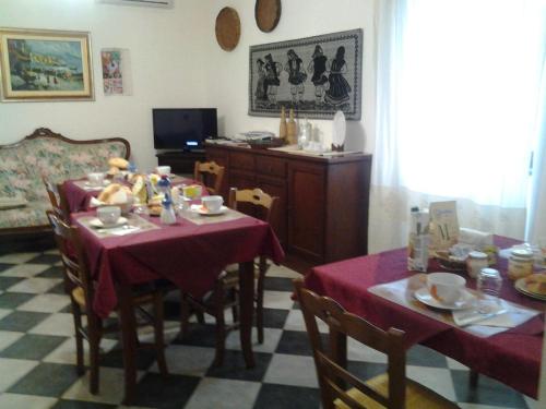 a dining room with two tables with red table cloth at Bed & Breakfast Casa Pisanu in Narbolia