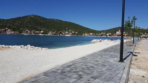a beach with the ocean and a street light at Apartments Anka in Vinišće