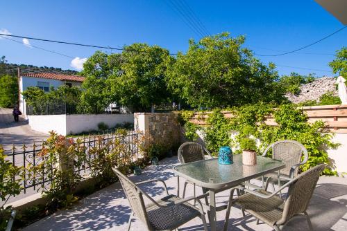 a patio with a table and chairs and a fence at On The Rocks in Theologos