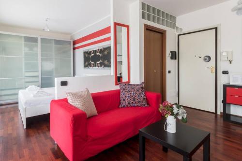 a red couch in a living room with a bed at Italianway - Carrara 5 in Milan