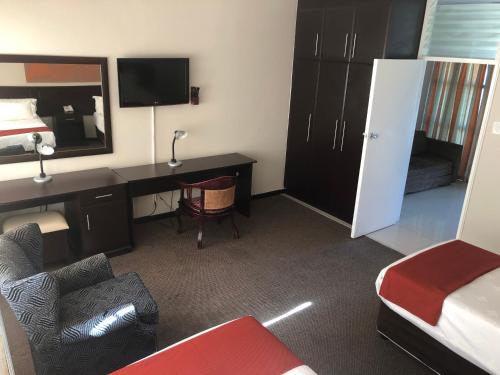 a hotel room with a desk and a bed and a bedroom at Coastlands Durban Self Catering Holiday Apartments in Durban
