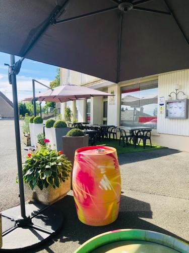 a colorful bag sitting on the ground under an umbrella at Logis Hôtel-Restaurant Le Commerce in Rieupeyroux
