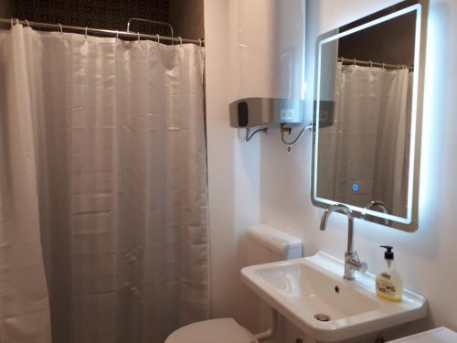 a bathroom with a white shower curtain and a sink at Apartment Adriatic in Makarska