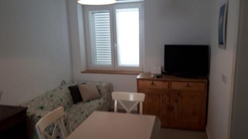 a living room with a couch and a television at Apartment Adriatic in Makarska