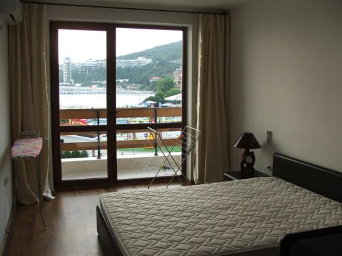a bedroom with a bed and a large window at Apartamens for rent at the beach bulgaria in Sveti Vlas