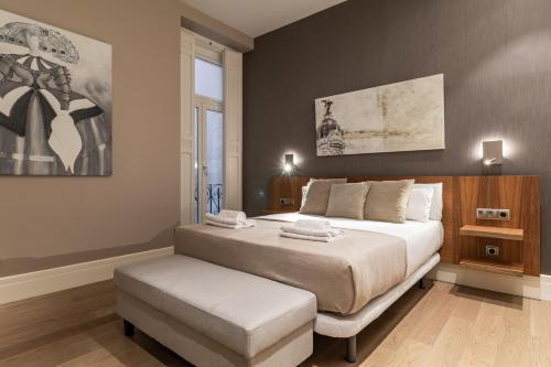 マドリードにあるSalamanca Luxury VIのベッドルーム(大型ベッド1台、スツール付)