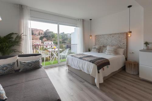 een slaapkamer met een groot bed en een balkon bij Lets Holidays Studio in Tossa in Tossa de Mar